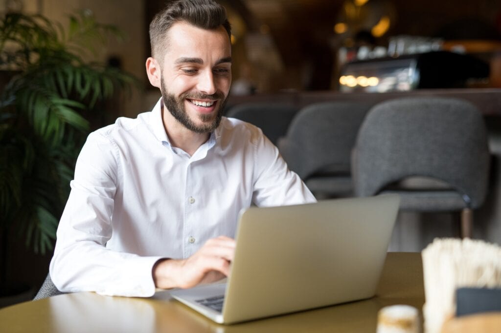 Cheerful Businessman Working in Cafe