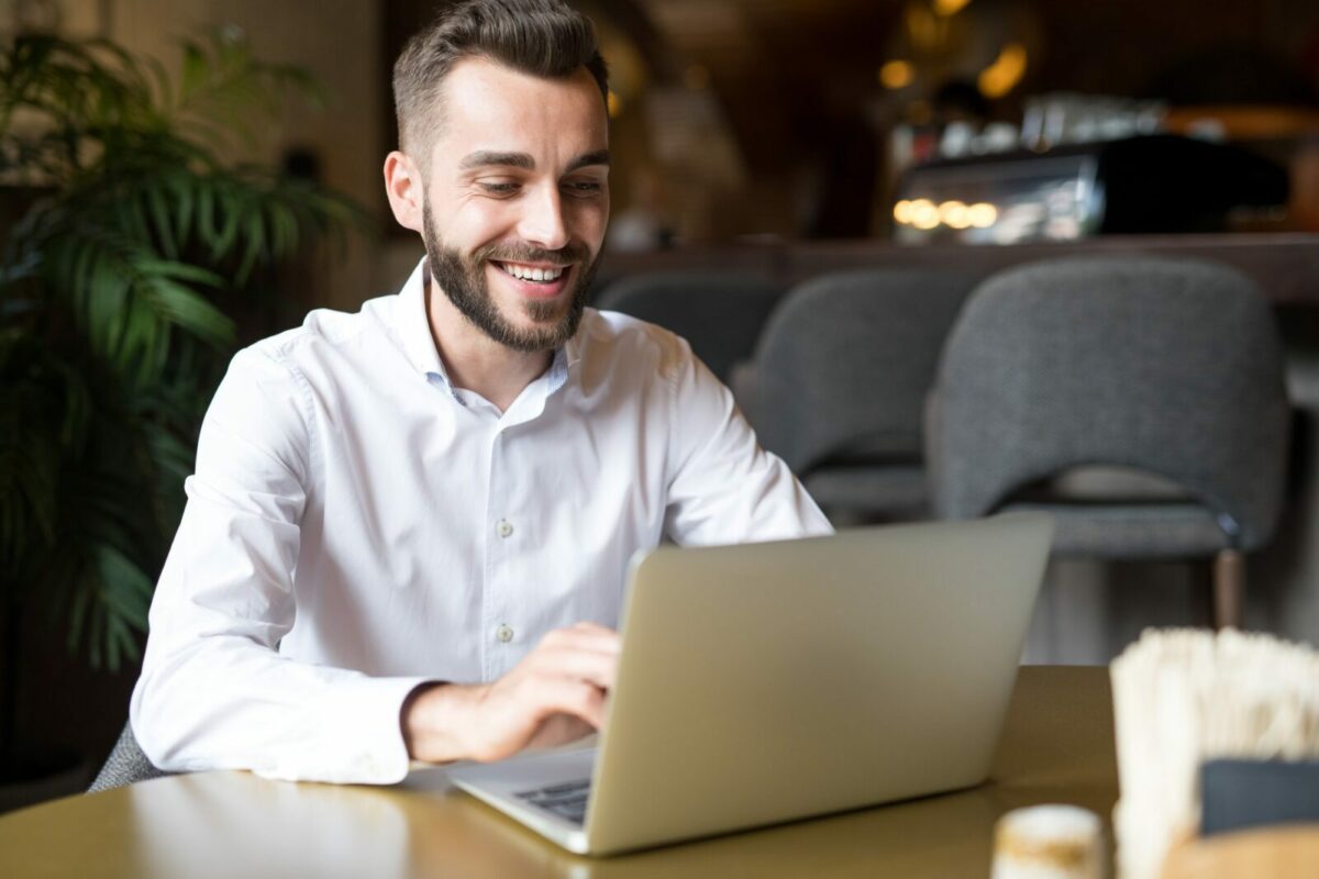 Cheerful Businessman Working in Cafe