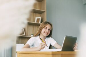 A cute girl is studying at home with a digital tablet, thinking about her homework